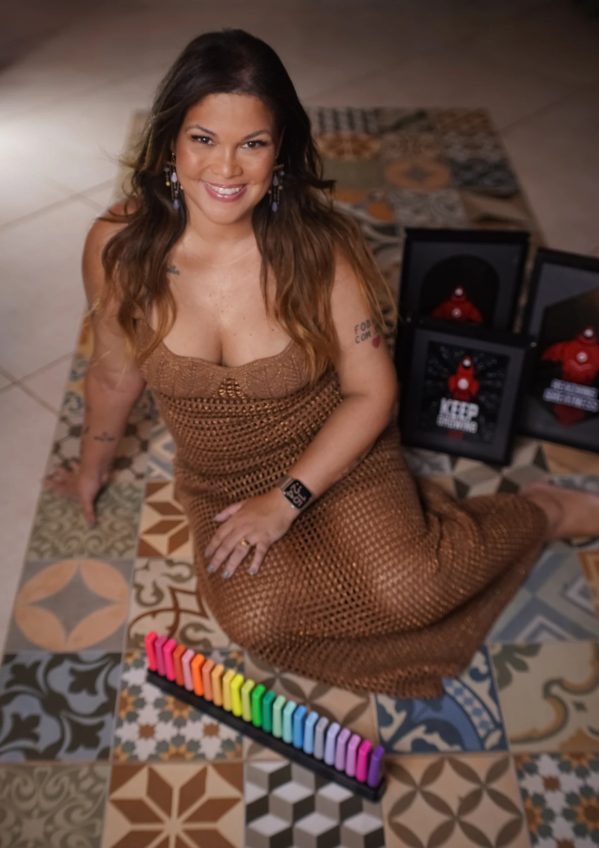 Isa Moreira sorrindo, sentada sobre um piso de ladrilhos